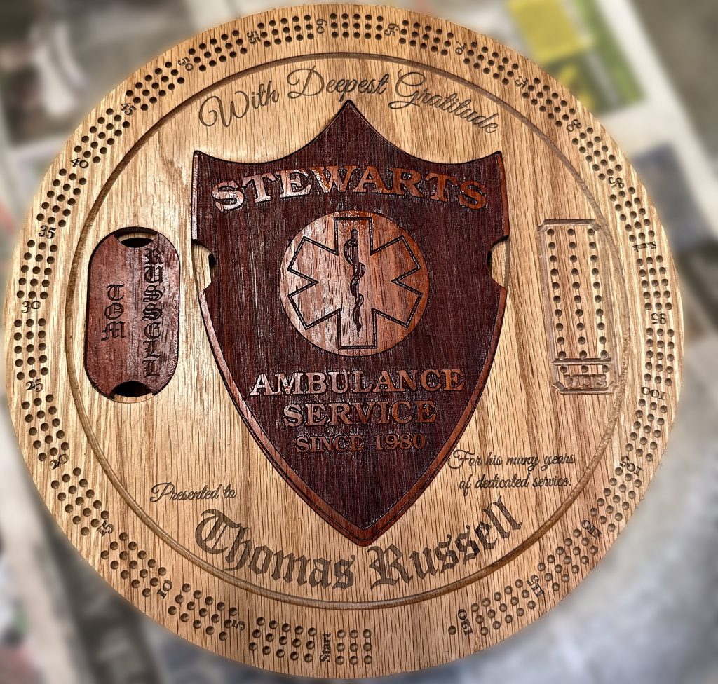 Handcrafted personalized retirement cribbage board with engraved ambulance service shield and built-in card and peg storage