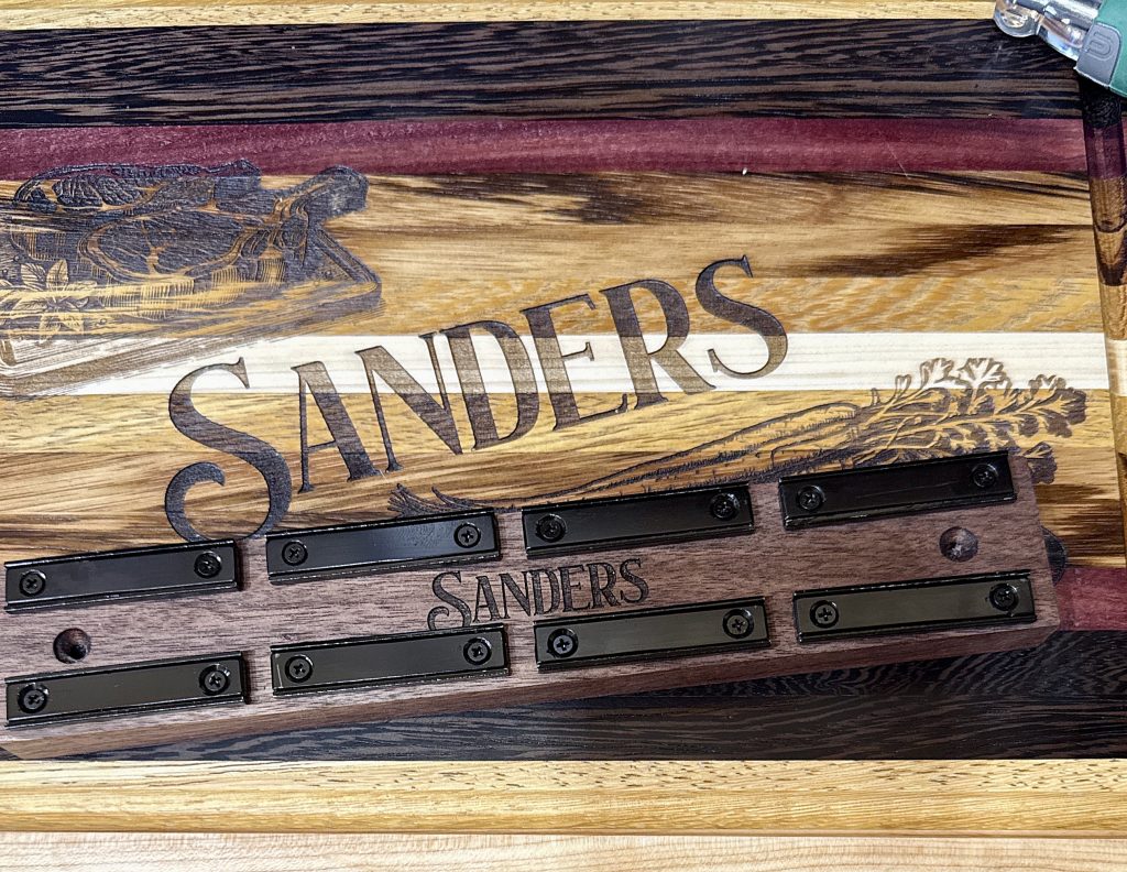 Brooks hardwood cutting board with laser-engraved detail and wall-mounted magnetic knife holder