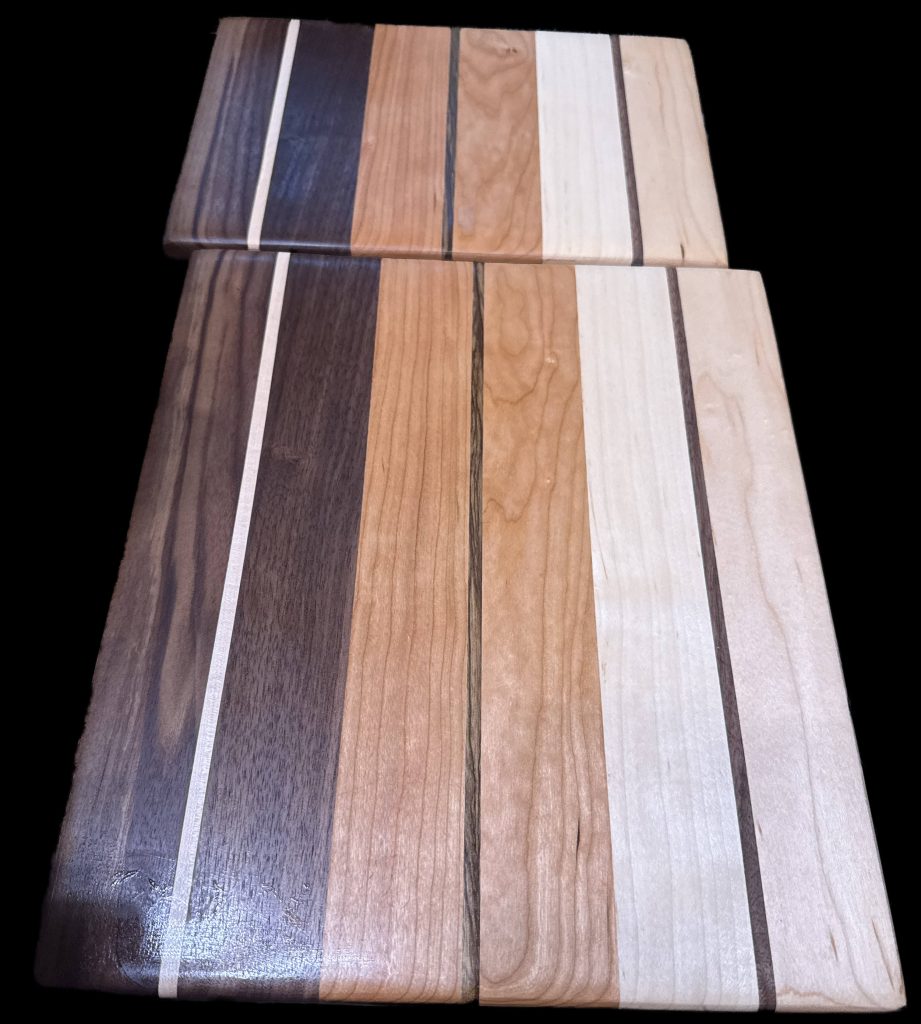 Set of custom thin hardwood cutting boards with striped walnut, maple, and cherry design, handcrafted kitchen prep boards