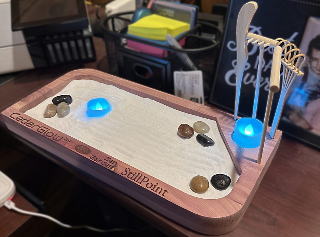 Handcrafted cedar Zen garden with sand tray, meditation rake, stones, and soft ambient lighting