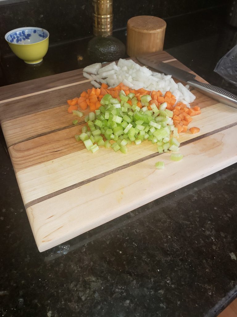 Handcrafted hardwood cutting board in use with chopped vegetables — custom woodworking by 3 Dogs Woodworking in New Hampshire