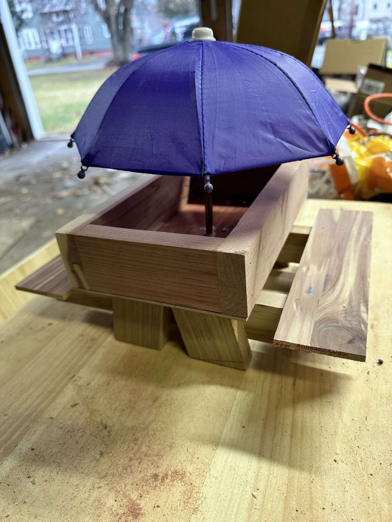 Handcrafted walnut and cedar squirrel feeder with picnic table design, custom outdoor wooden wildlife feeder.
