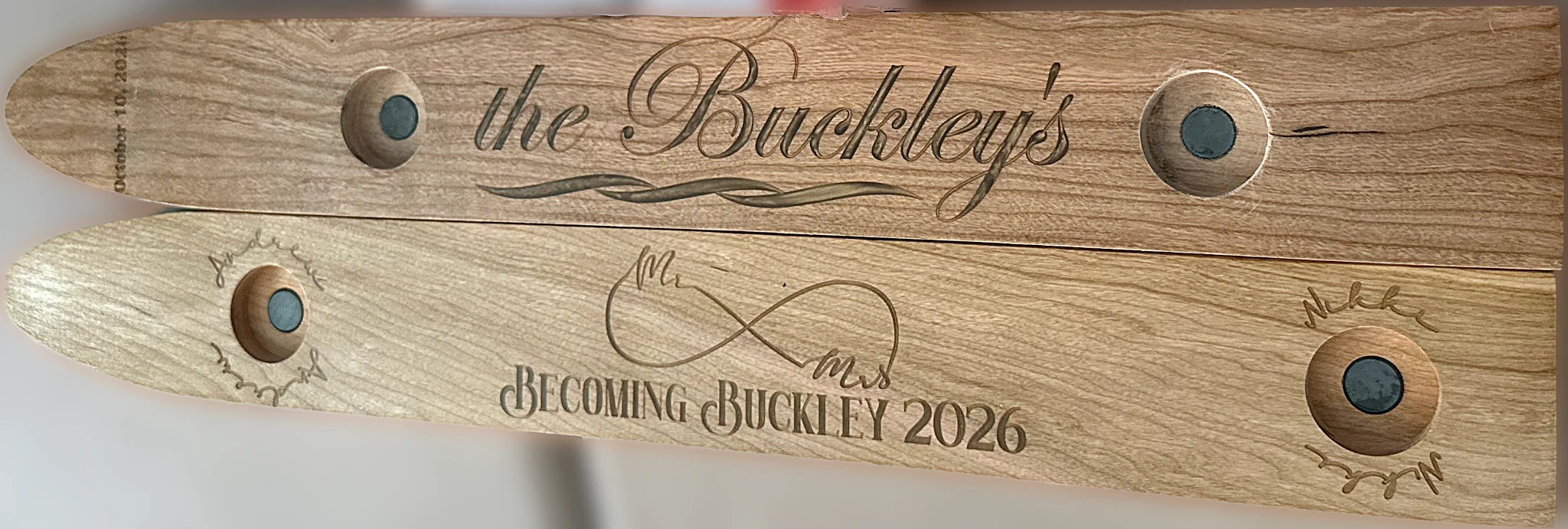 Two personalized wooden shotskis made for the Buckleys, one engraved for their 2026 wedding