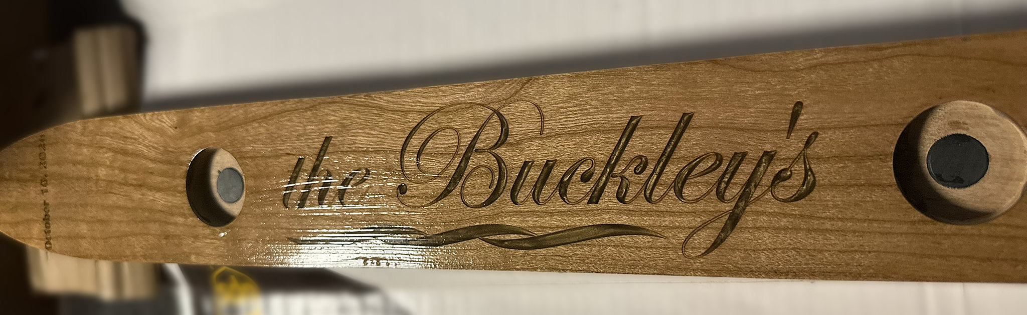 Close view of the Buckleys’ custom cherry Shotski showing magnetic glass bases and personalized gold epoxy details